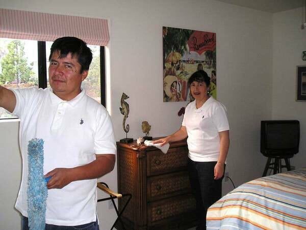 Tony and Martha Nava cleaning a bedroom